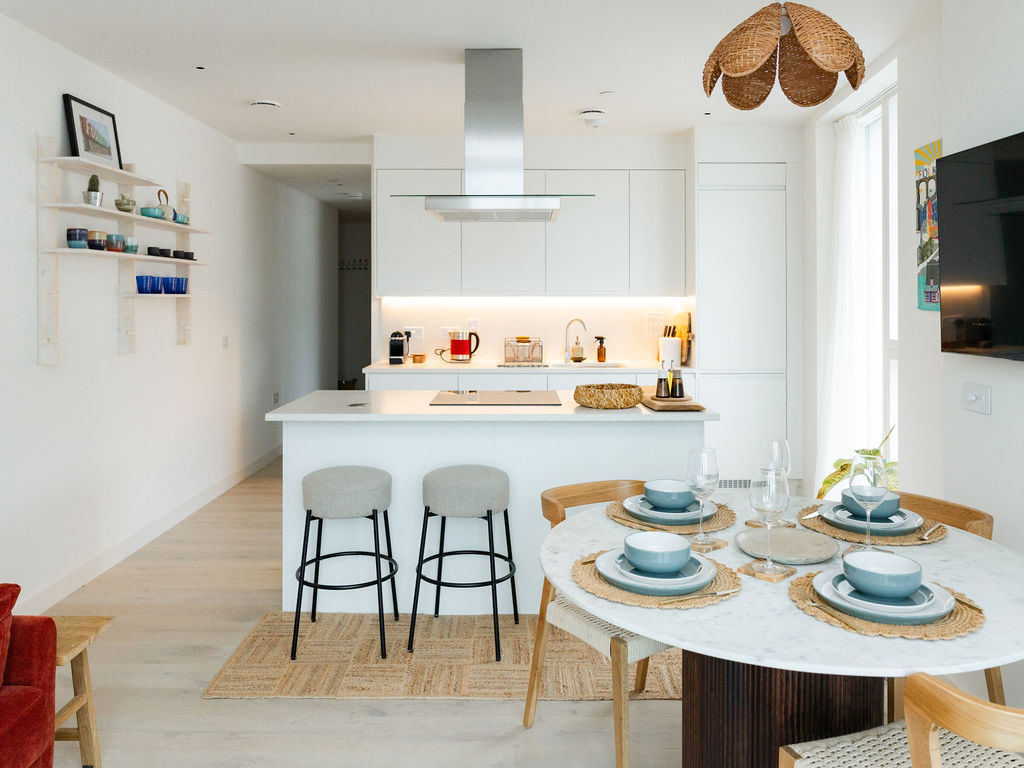 Open-plan kitchen with island, breakfast stools and dining table